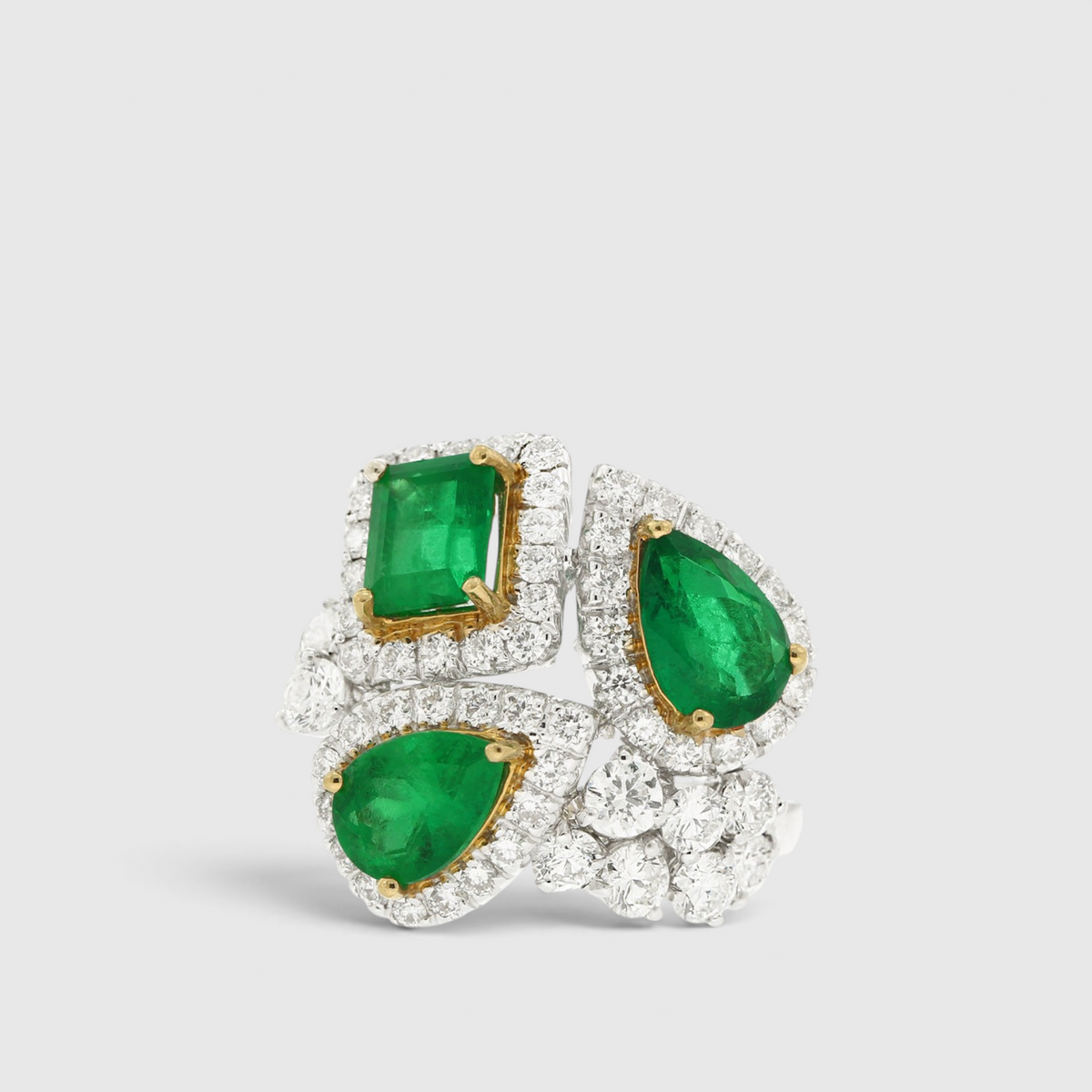 hofjewellery 18K white gold ring with three Colombian emeralds and a diamond halo cluster in an asymmetrical design.