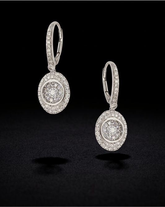 Oval illusion-set diamond drop earrings with diamond halos and hooks in 18K white gold, reference 1951E.