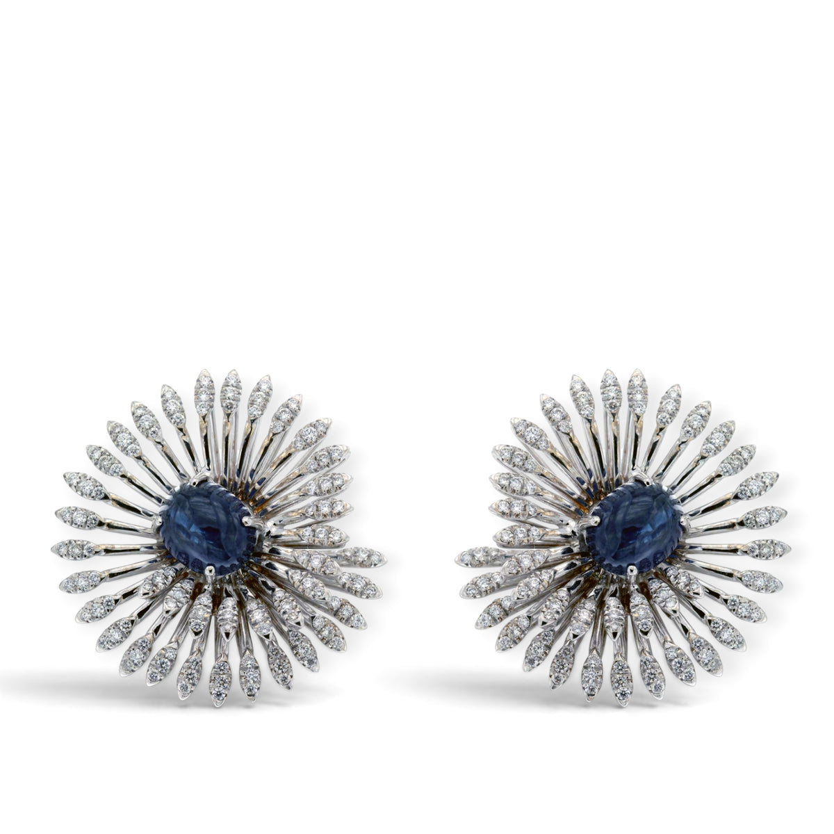 Front view of the pair of blue cabochon sapphire earrings with radiating diamond-set swirls in 18K white gold, reference 4216.