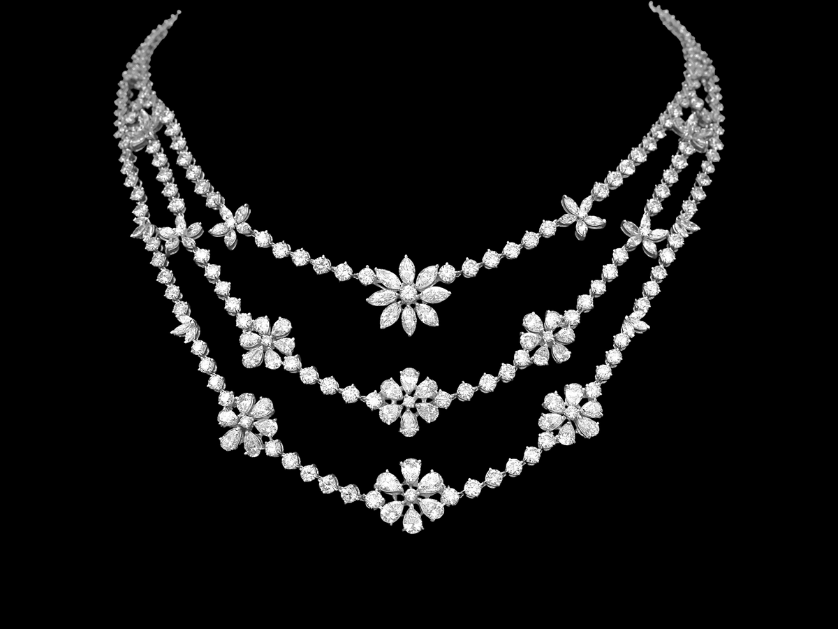 hofjewellery Musetta 18K white gold three-line necklace featuring floral diamond clusters on a black background.