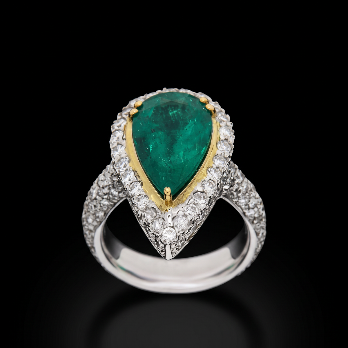 hofjewellery pear-shaped Colombian emerald ring with a diamond halo set in 18K white gold on a black background